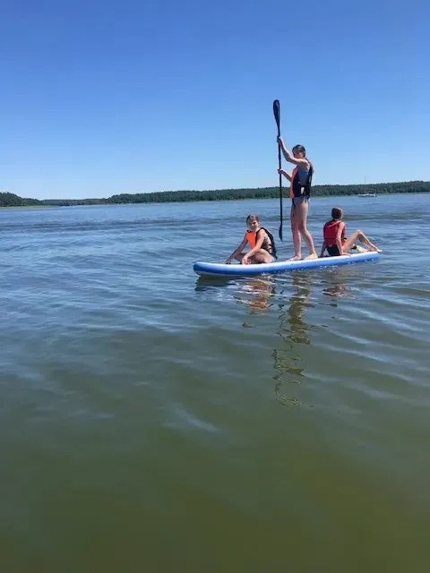 Aktywny relaks na desce SUP o poranku na spokojnej tafli jeziora w Kozinie
